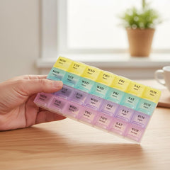 Pastel-colored 28-slot weekly pill organizer with multiple compartments.